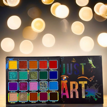 Just Art palette open beside its box under warm string lights, pan names legible across the shade grid