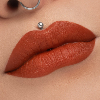 October worn on the lips, fair skin tone, with a septum ring and lip piercing in frame
