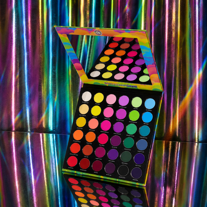 Arch of Color palette open and angled, lid mirror reflecting the rainbow pans, on a holographic iridescent backdrop