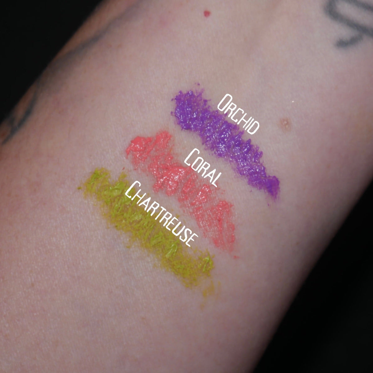 Three arm swatches on light skin, labelled Orchid, Coral and Chartreuse.