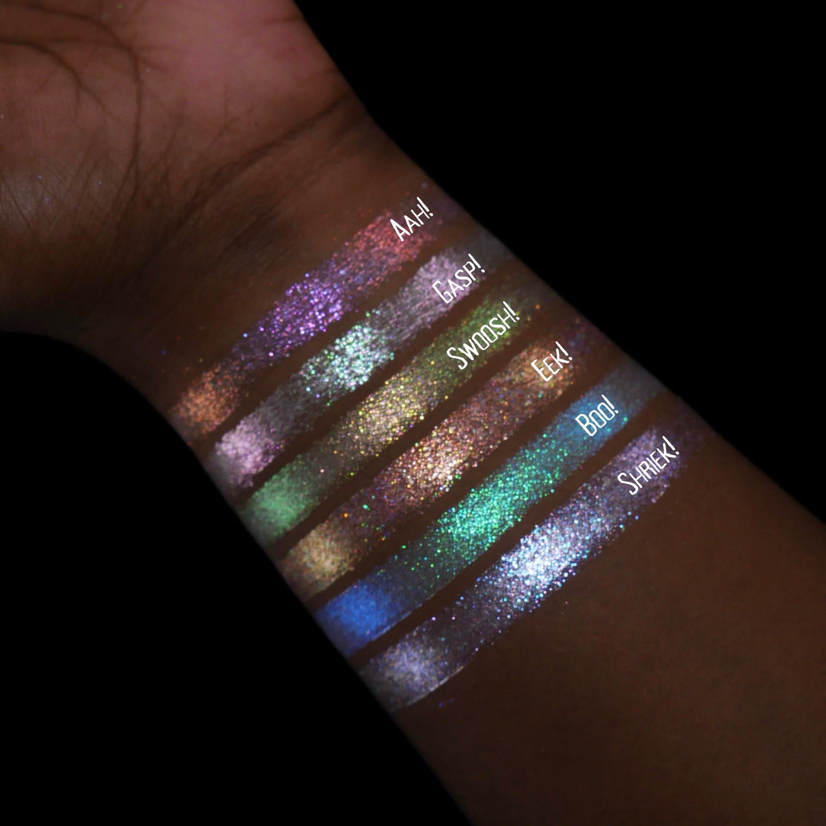 The six swatches on an arm in near-darkness, labelled Aah!, Gasp!, Swoosh!, Eeek!, Boo! and Shriek!, catching the light.