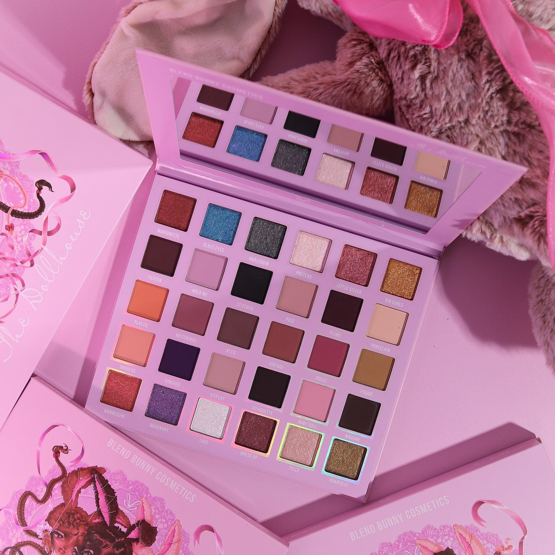 The Dollhouse magnetic palette open with its mirror, propped beside a plush bunny and closed boxes