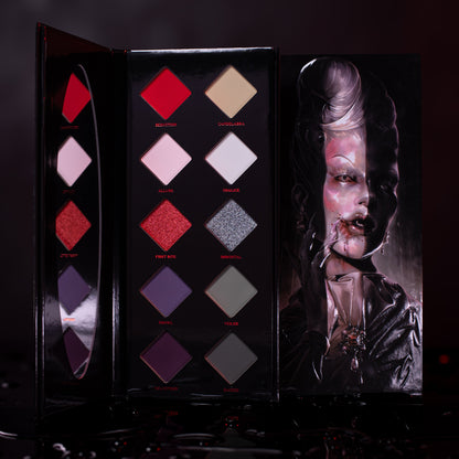 First Bite mini palette open, ten diamond pans of reds, pinks, creams, greys and purples with red and silver shimmers, vampire lid art.