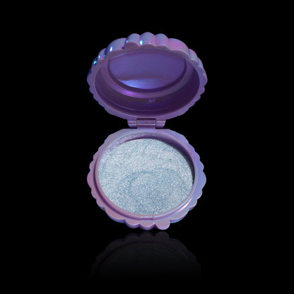 Unearthly Cosmetics Ghoulight face and body glow in Dewlight, open iridescent purple seashell compact showing the silver-blue glow pan