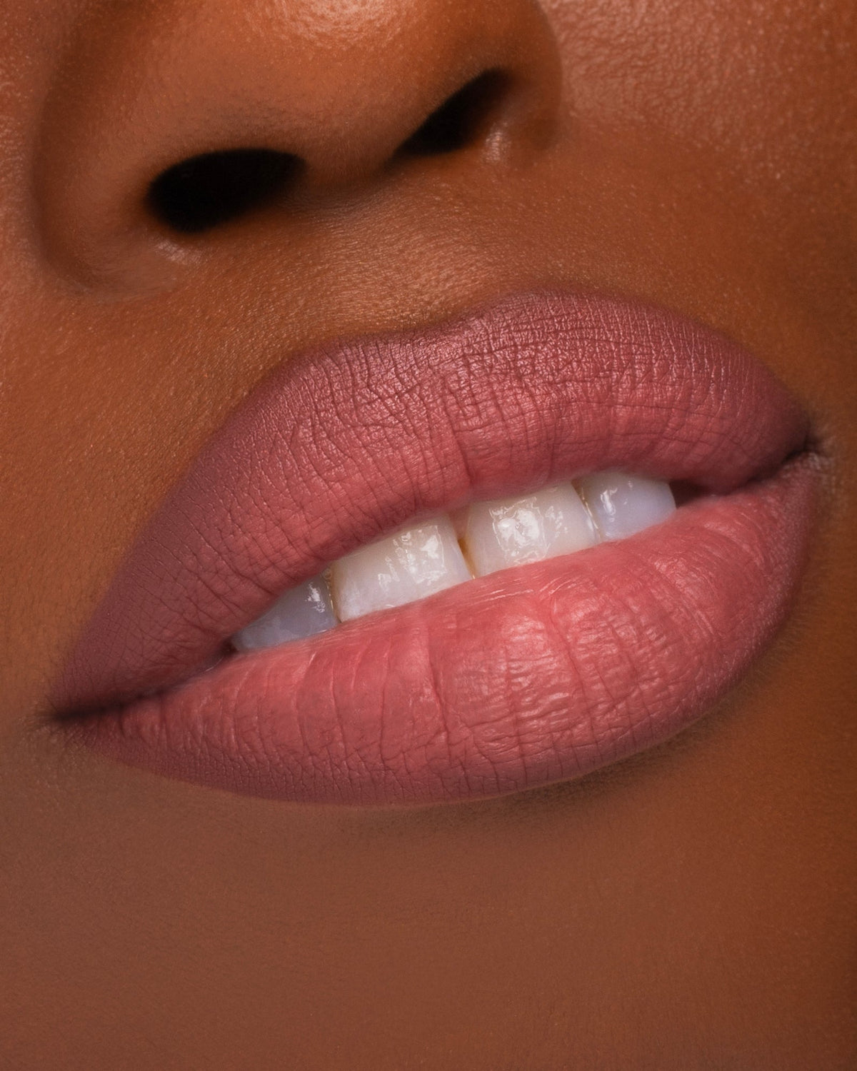 Bewitched worn on the lips, mauvy pink on a deep skin tone