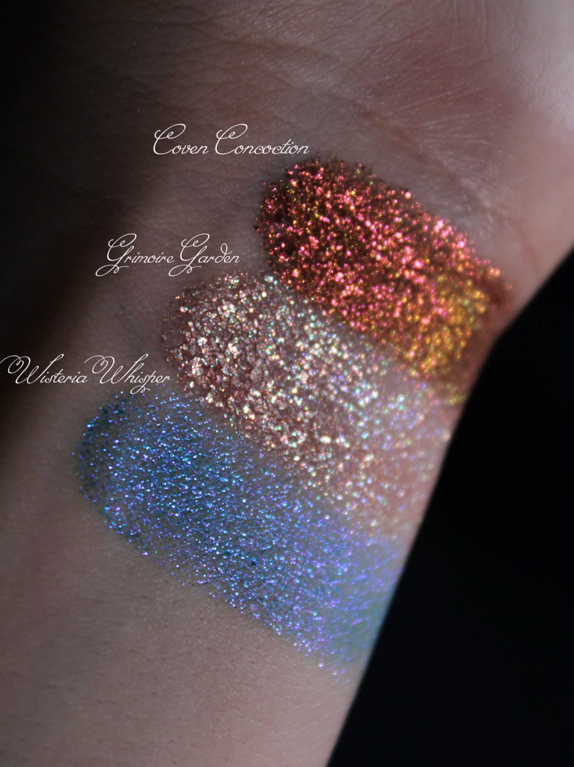 Labelled swatches of Coven Concoction, Grimoire Garden and Wisteria Whisper on light skin.