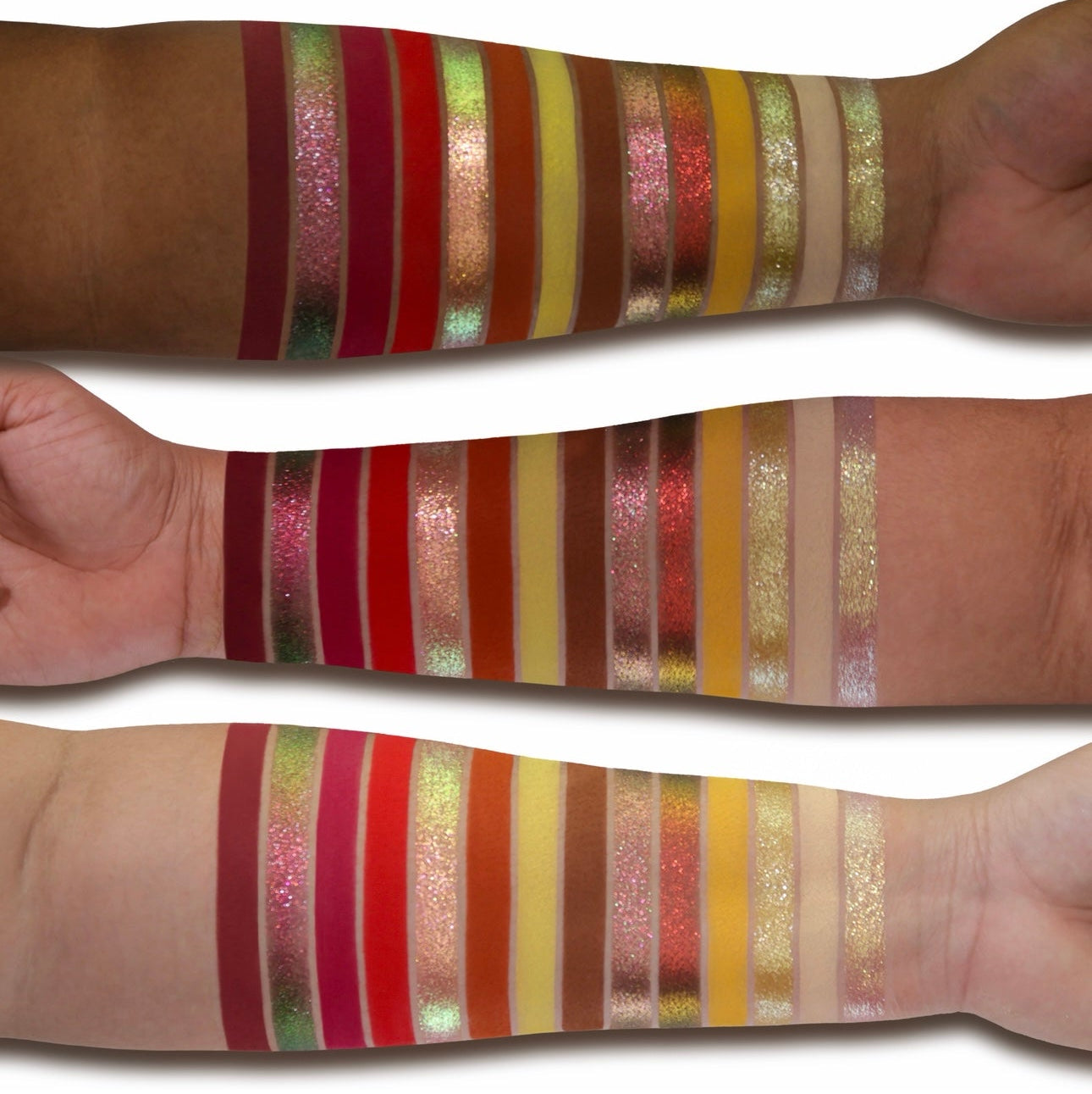 Pandemonium swatches on three skin tones, the full range swiped side by side: burgundy, pink and green sparkles, reds, rusts, yellows and gold
