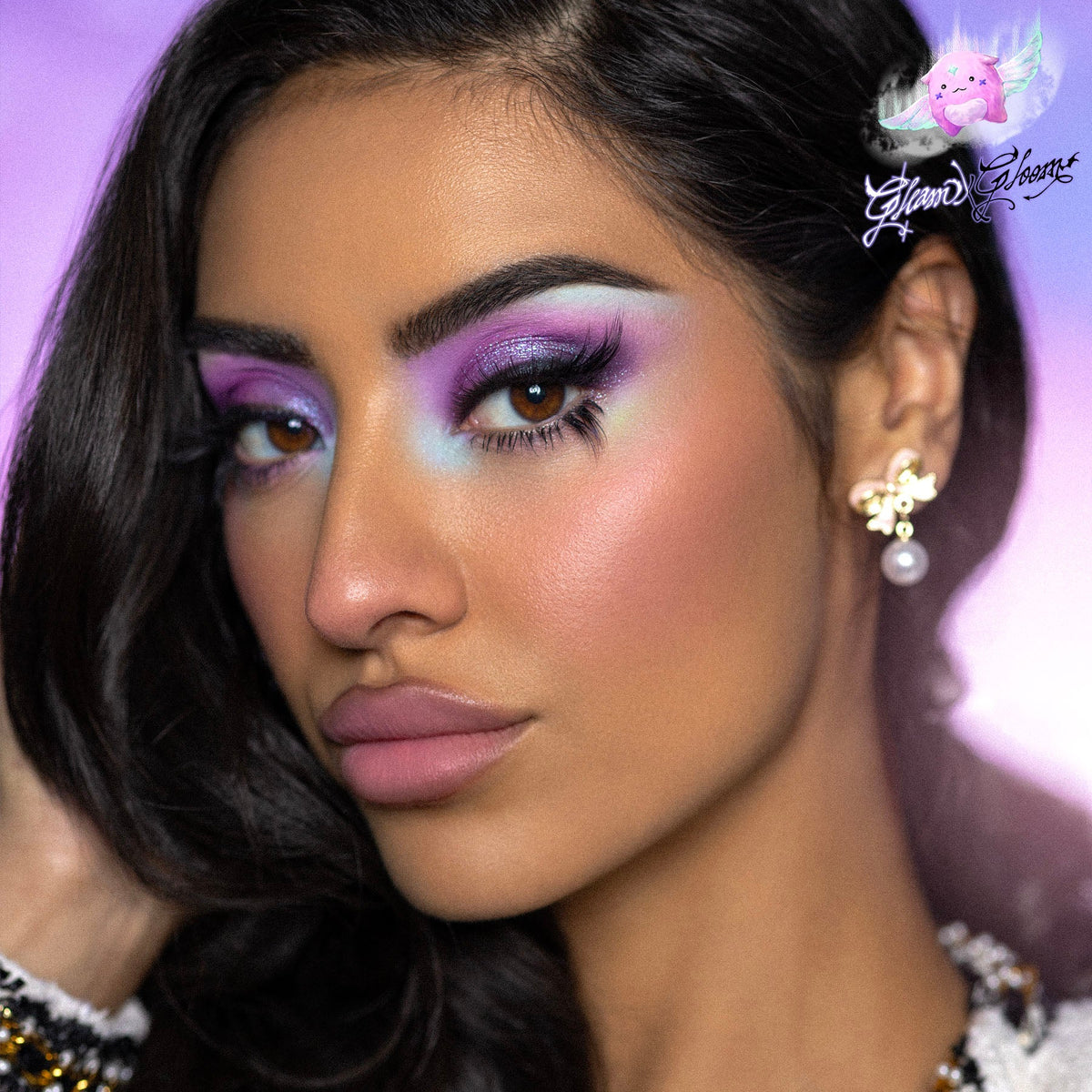 Model wearing a Gleam eye look, lilac and pink shadow with a graphic liner wing and pink highlight.