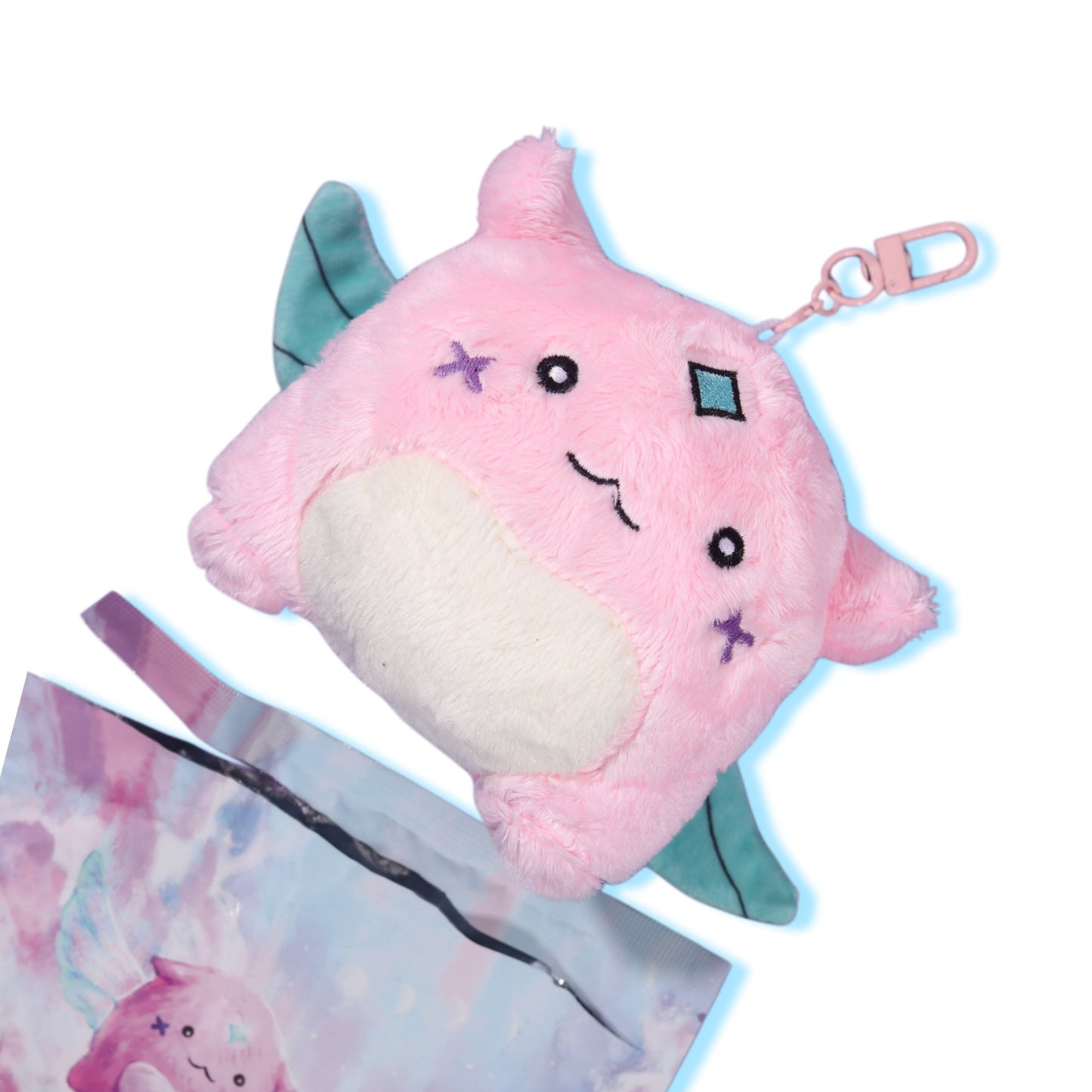 Gleam plush keychain with its metal swivel clip visible, resting against its printed packaging pouch.