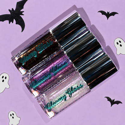 Seance Shimmer, Purple Potion and Moonlit Magic tubes lying diagonally on a lilac backdrop with black paper bats
