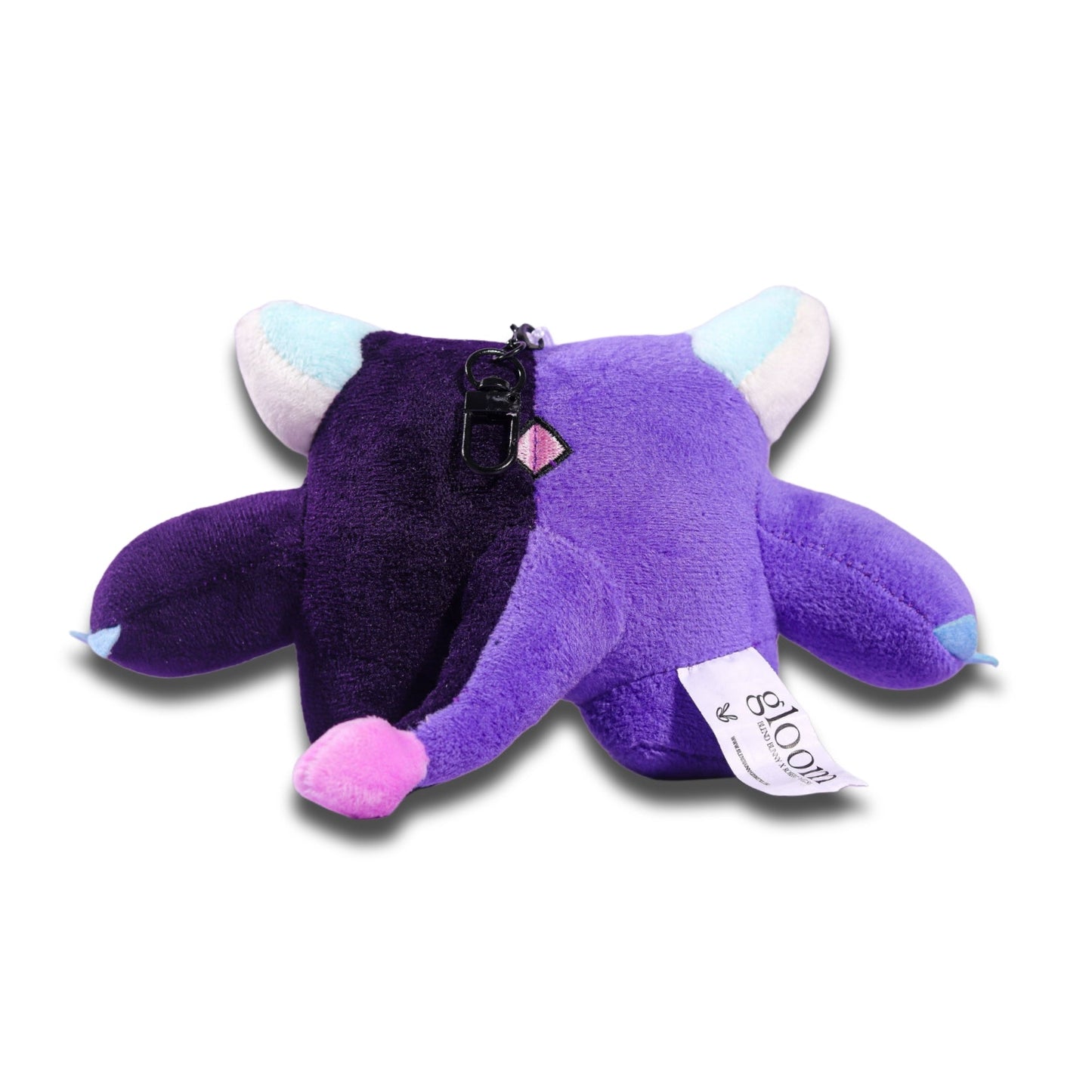 Back of the Gloom plush keychain, purple fabric with the attachment loop at the top and a printed hang tag.