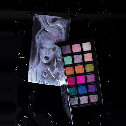 The Final Offering palette open on a wet black surface, the ghost lid art standing behind the 18 shimmer pans.