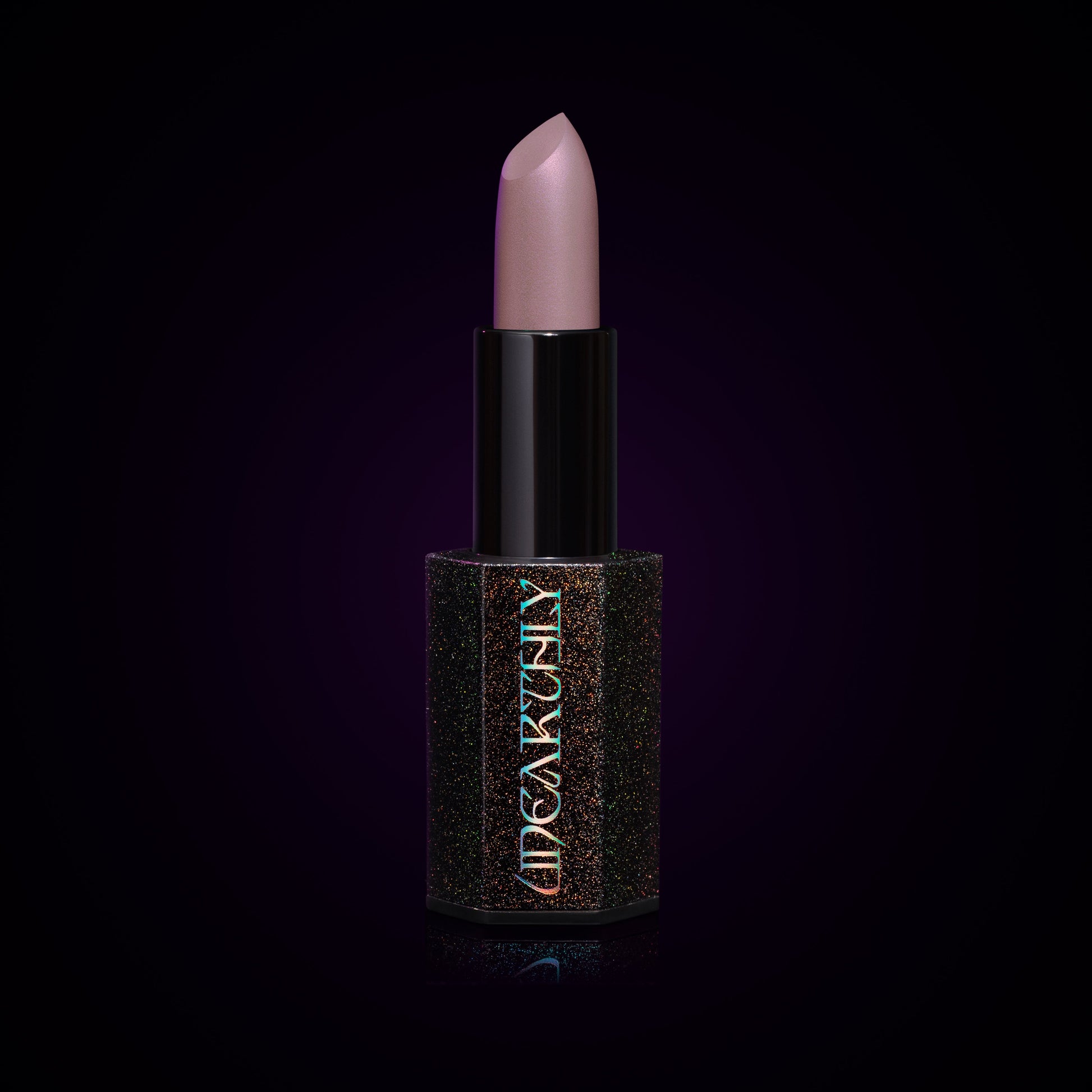 Ghost Milk lipstick bullet, pale lavender-grey cream in a black holographic-speckled tube on a dark background