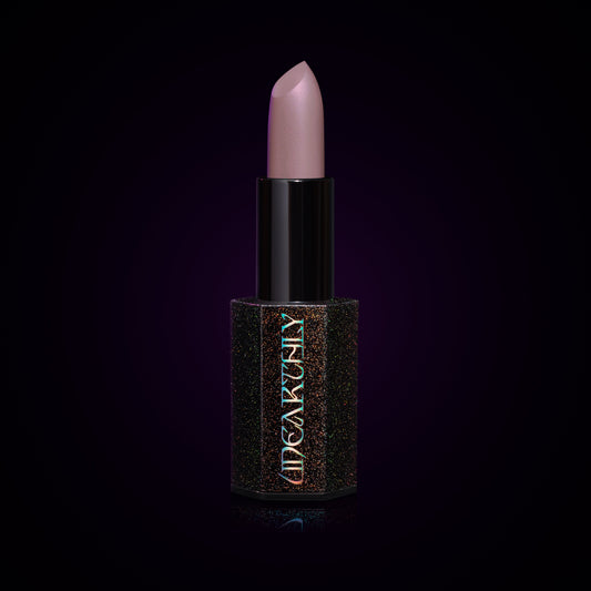 Ghost Milk lipstick bullet, pale lavender-grey cream in a black holographic-speckled tube on a dark background