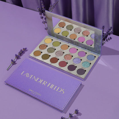 Simply Posh Lavender Fields eyeshadow palette open and closed on a lavender background, lilac faux-leather cover with gold lettering and 18 pans inside