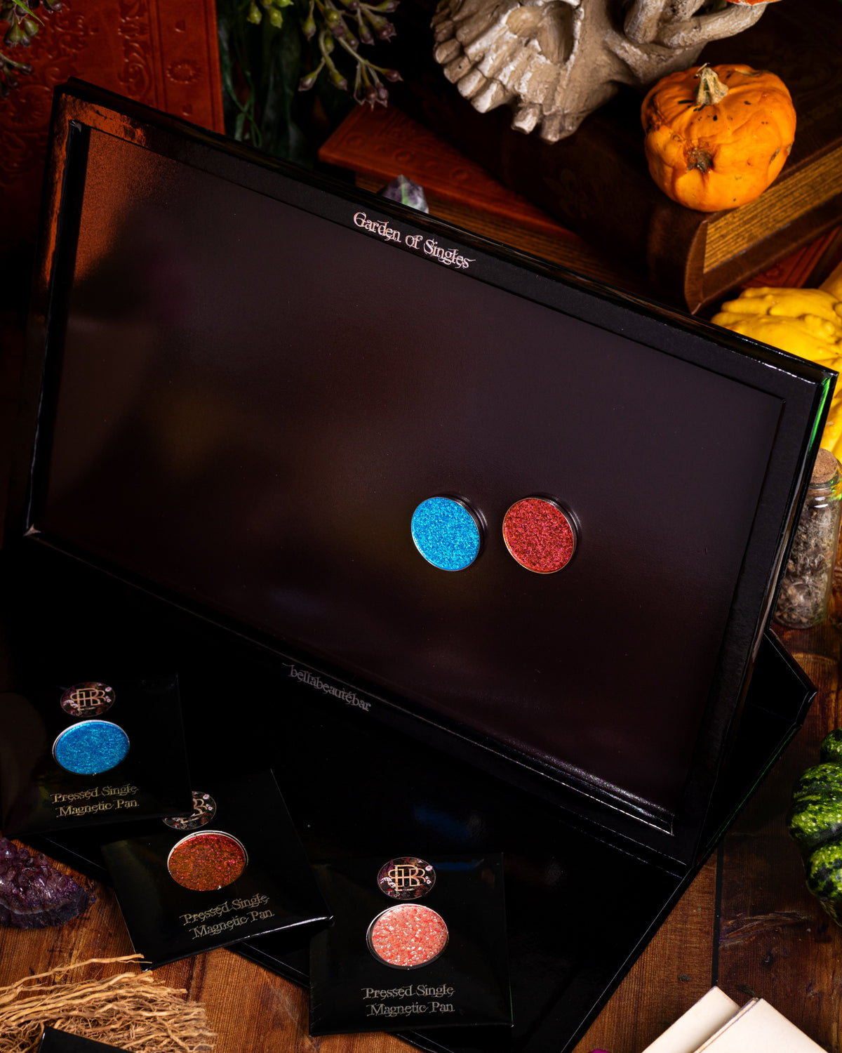 The Garden of Singles palette open and standing up, two pressed pigment singles inside and three more in their sleeves in front