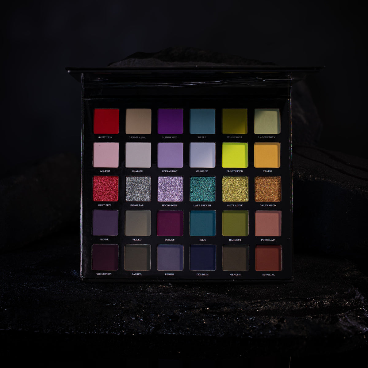 The 30 Ellis V3 pans in five rows of six, lit low on a dark rock set, the row of six shimmers across the middle.
