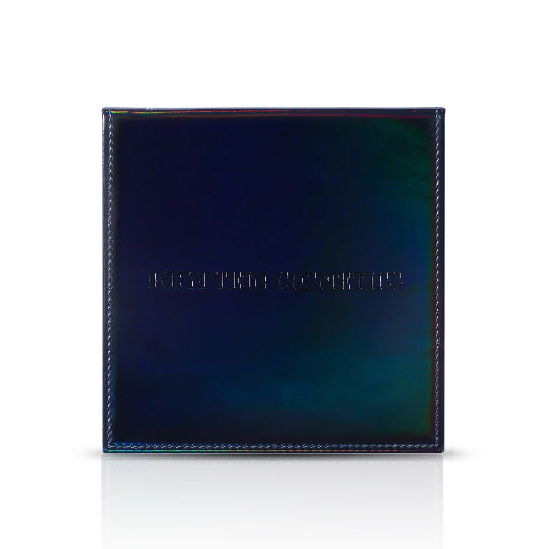 Kryptein Supernova palette closed on white, iridescent navy cover shifting to green and teal with embossed Kryptein Cosmetics logo