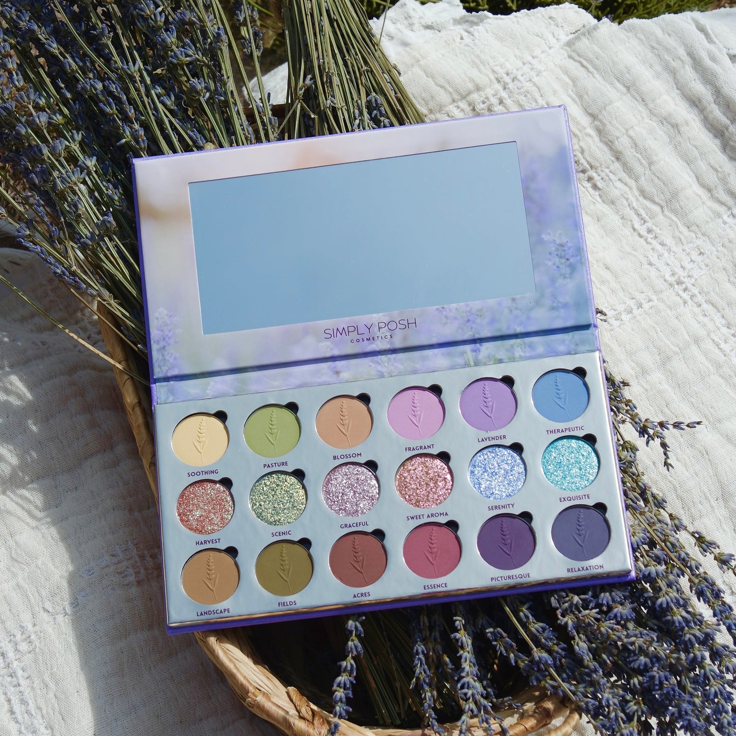 Lavender Fields palette open on a bundle of dried lavender in a basket, mirror lid reflecting the sky