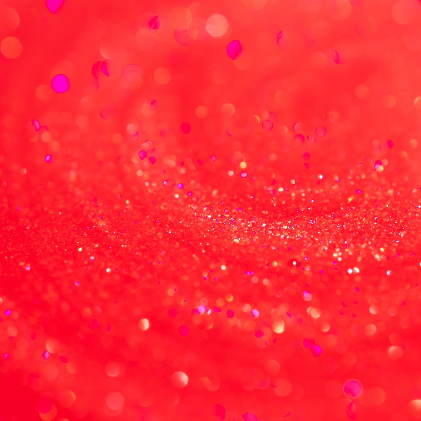 Close-up of the Embered lip oil, sheer red with fine gold and pink sparkle