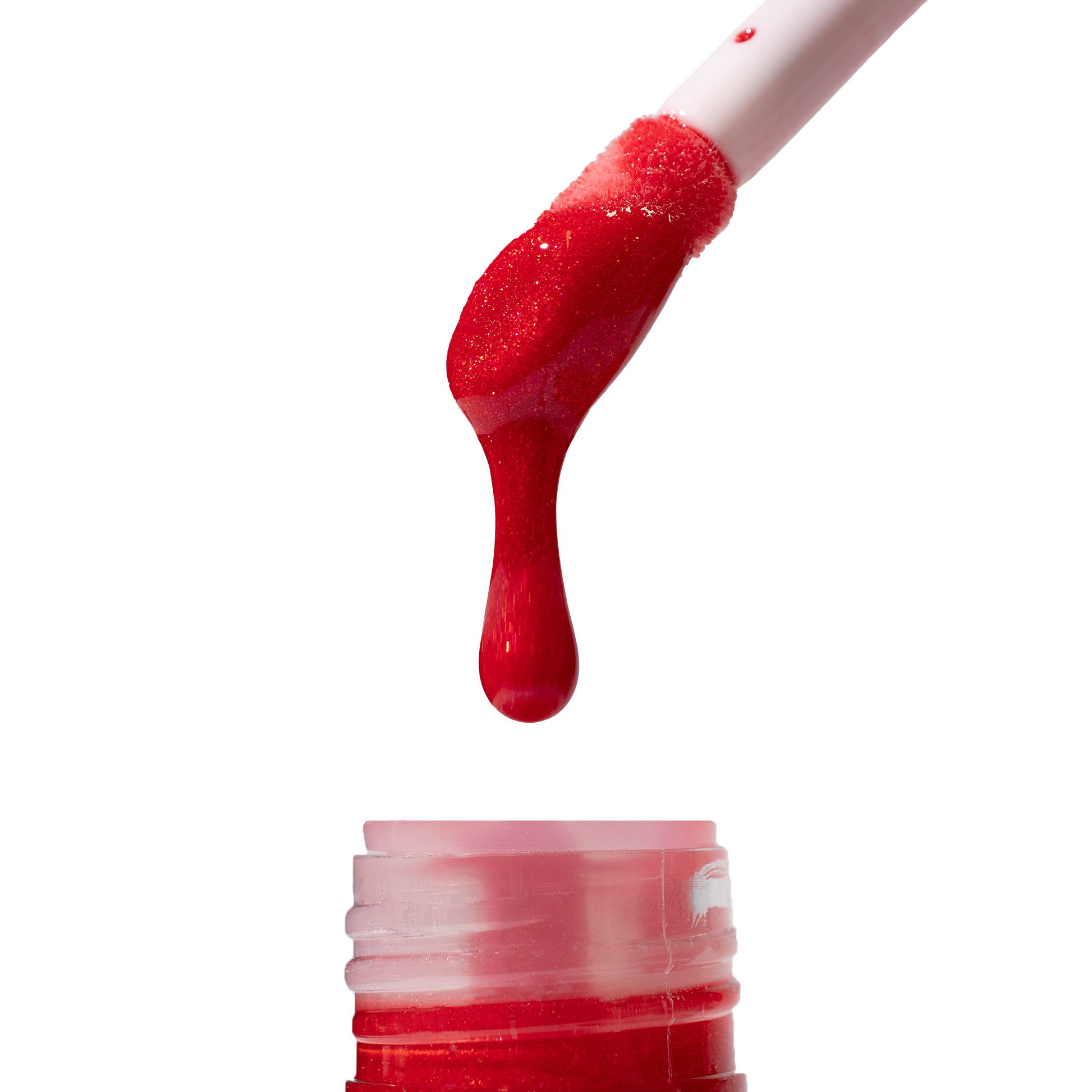 Embered lip oil applicator dripping the red oil back into the bottle