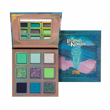Lethal Raava eyeshadow palette from the Legend of Korra collection, open beside its blue sleeve, showing nine green, teal, gold, and blue shades