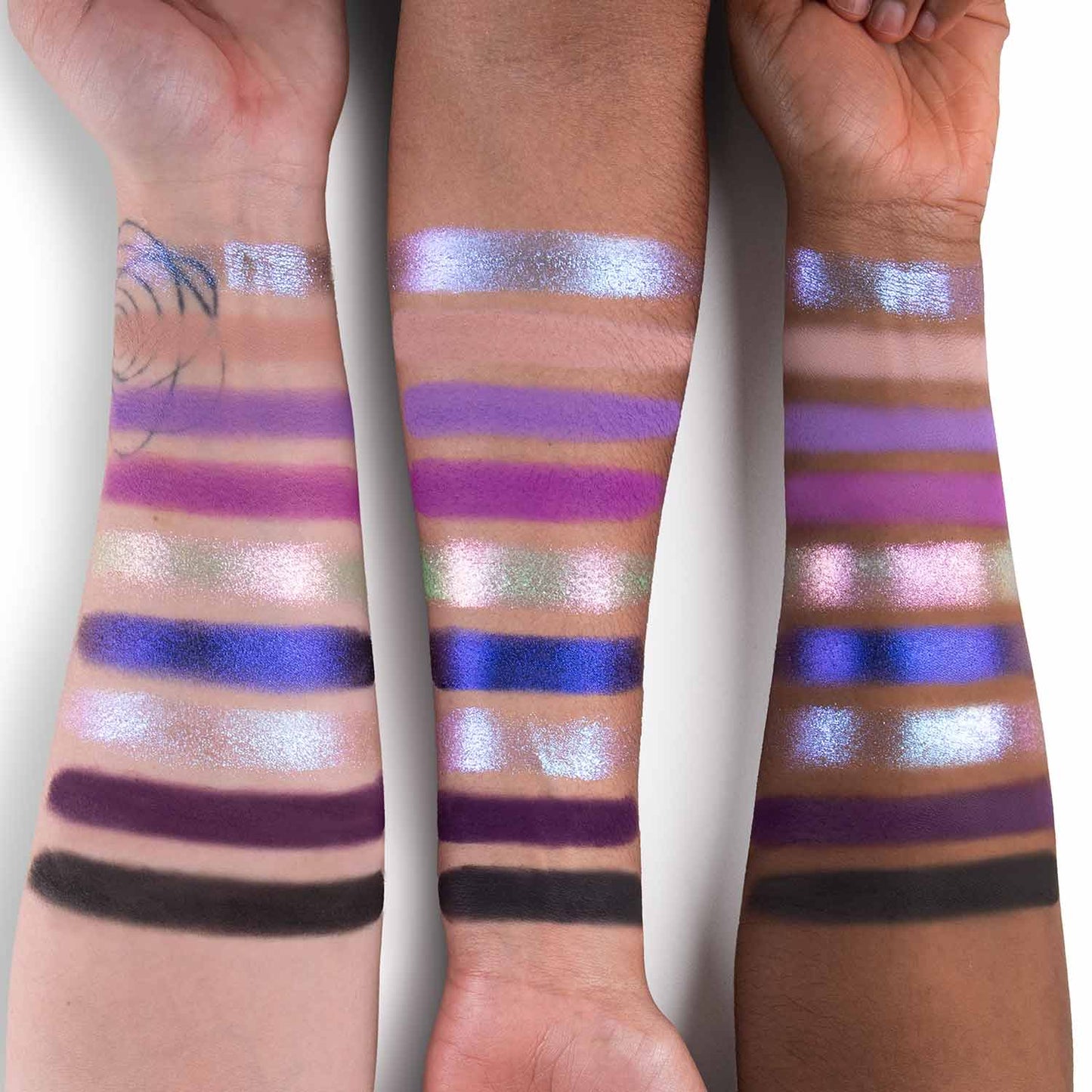 Vaatu palette swatched on three skin tones: purples, periwinkles, teal, plum, and a deep matte across nine shades