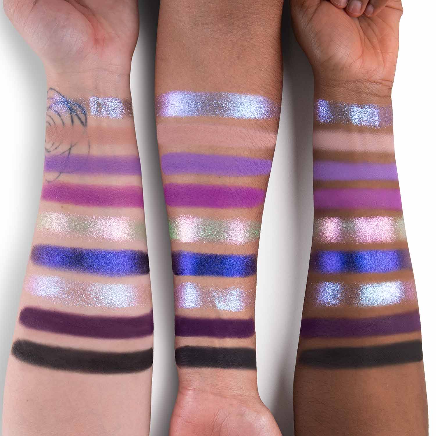 Vaatu palette swatched on three skin tones: purples, periwinkles, teal, plum, and a deep matte across nine shades