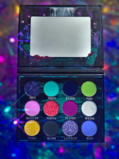 Cosmic Cove palette open on a holographic backdrop, vertical view with the mirror at top and twelve pans arranged in three rows below