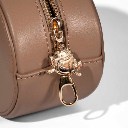 Close-up of the Jason Funderberker frog zipper pull and snap clasp on the tan bag