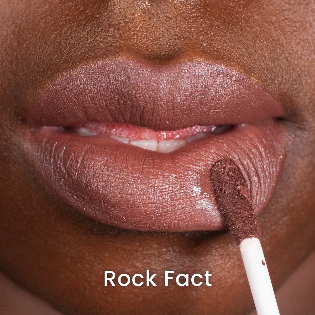 Rock Fact applied on deep skin, rich brown, labelled with the shade name
