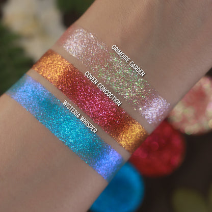 Labelled swatches of all three singles on light skin, with the pans behind.