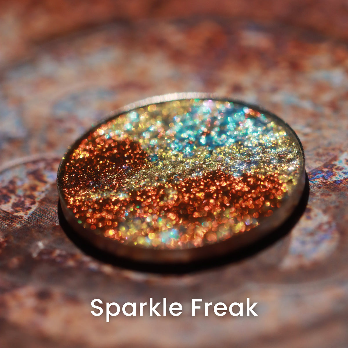 Sparkle Freak pan close-up on rusted metal, marbled copper-red and teal with gold sparkle