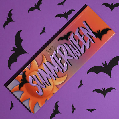 Closed Summerween palette with an orange sunset lid, purple SUMMERWEEN lettering, a sun and bats, on a purple bat-print background