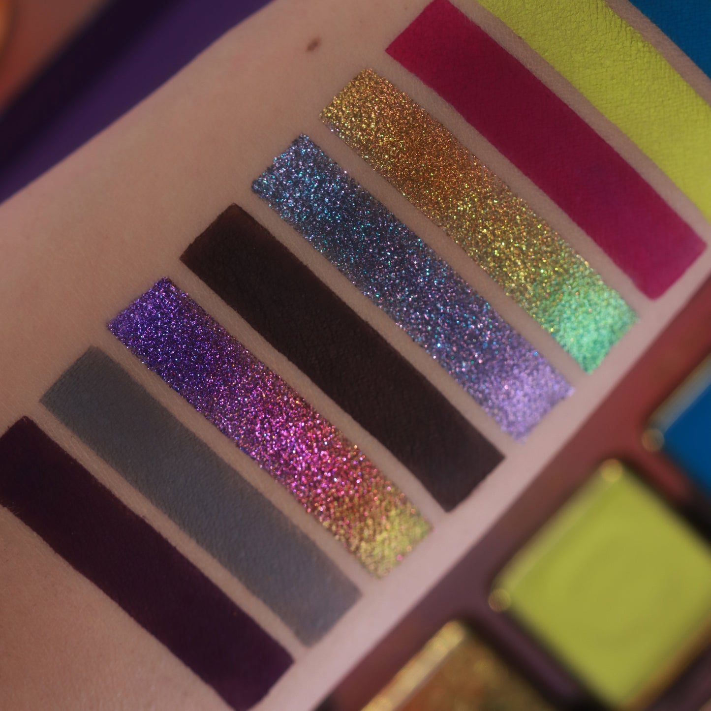 Close-up of Summerween sparkle swatches, a violet, a blue-green, and a gold colour-shifting stripe beside deep matte browns