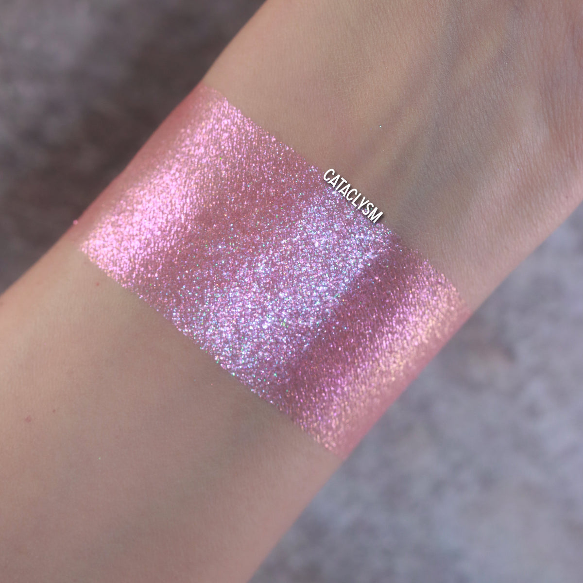 Cataclysm swatch: pink sparkle shifting to violet and lilac on a light skin tone