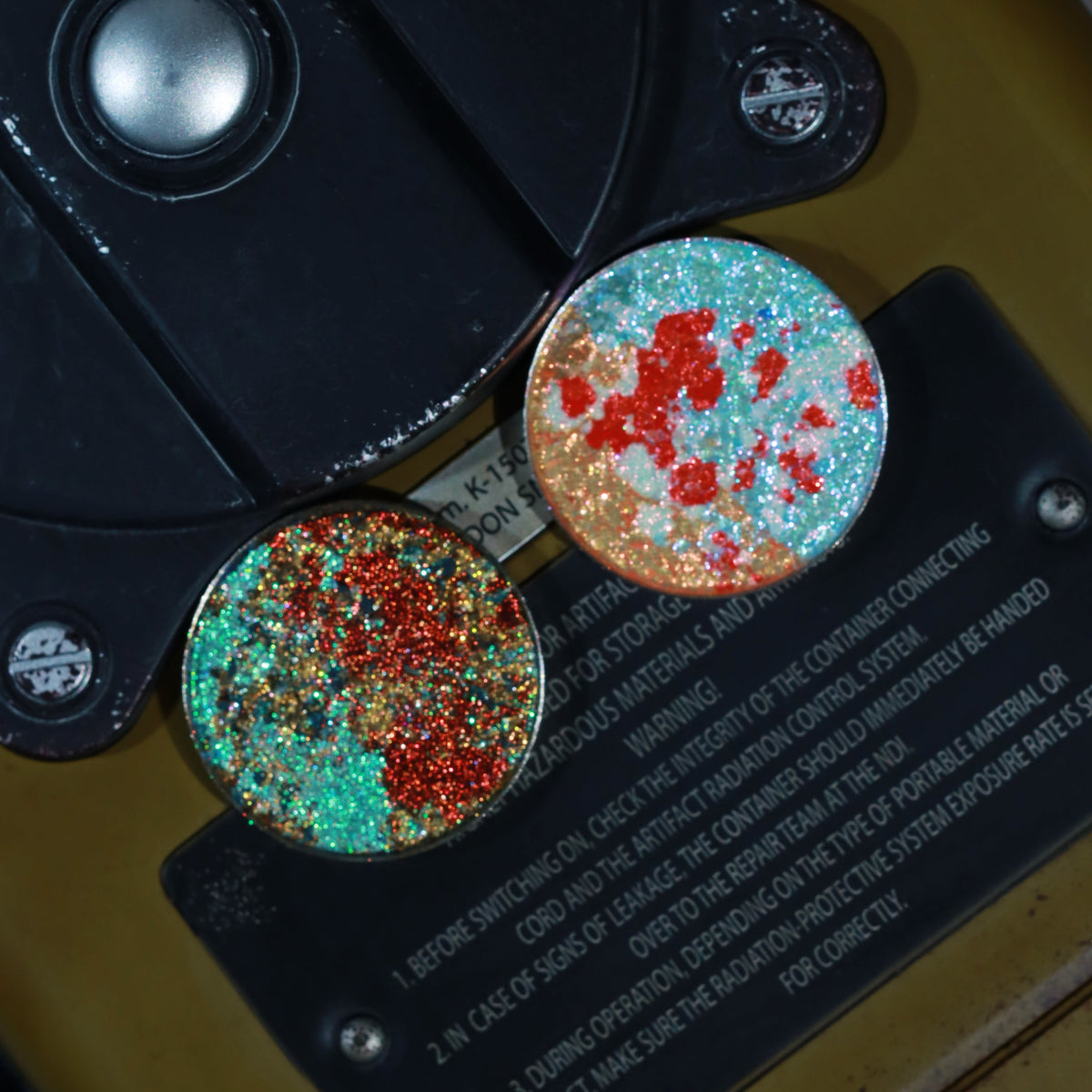 Sparkle Freak and Cataclysm pans together on a black equipment plate printed with radiation warning text