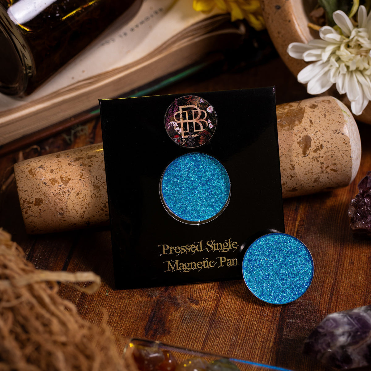 Wisteria Whisper on its pressed single magnetic pan card, with a loose pan, among dried herbs and bottles.