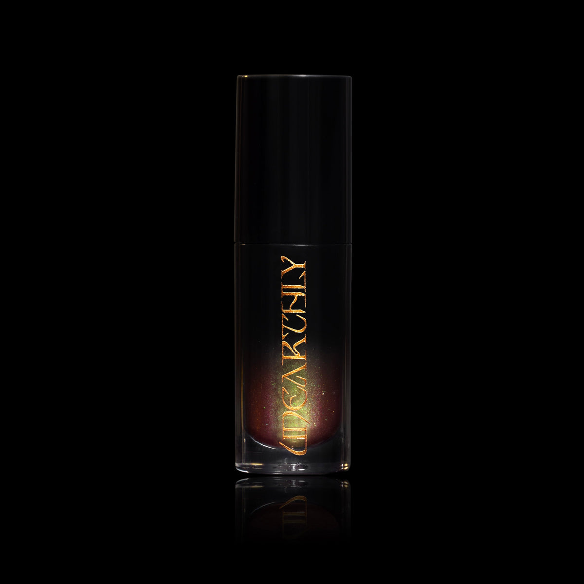 Witches Brew in a clear tube with a black cap and gold Unearthly logo, rusty gloss with a green shift showing through