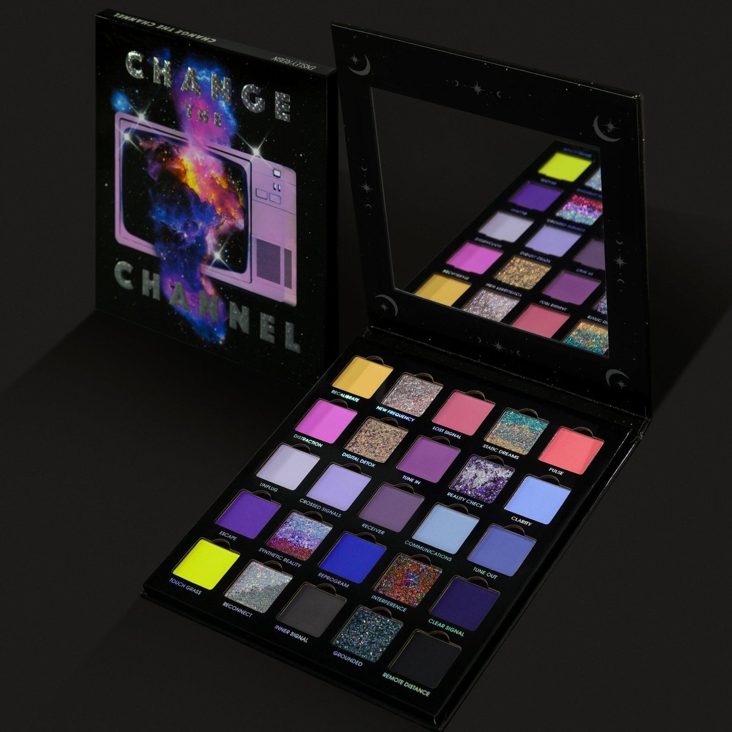 Ensley Reign Change the Channel eyeshadow palette open beside its cosmic TV-static box, showing 25 pans of brights, pastels, and multichrome sparkles