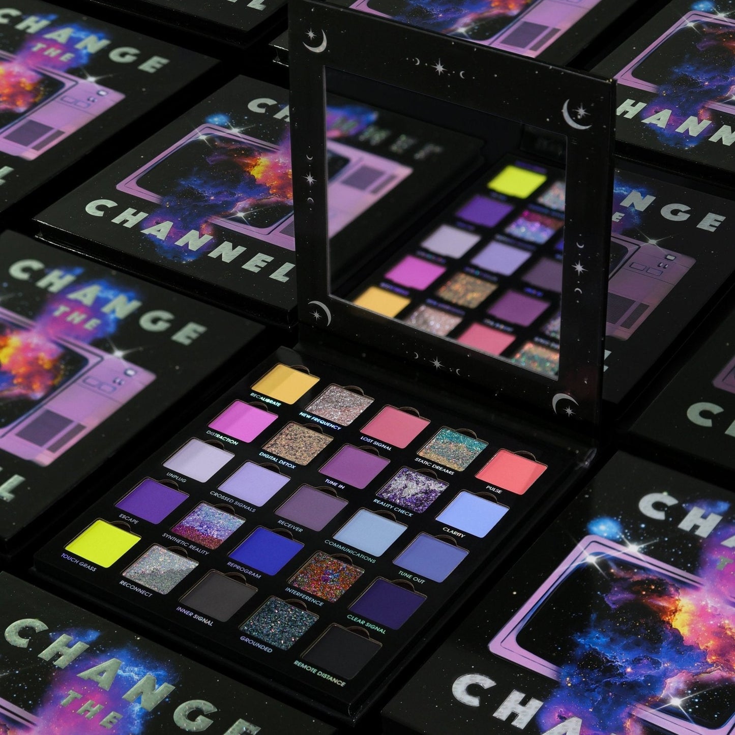 Several closed Change the Channel boxes with cosmic television cover art around one open palette and its mirror