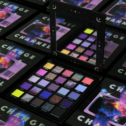 Several closed Change the Channel boxes with cosmic television cover art around one open palette and its mirror