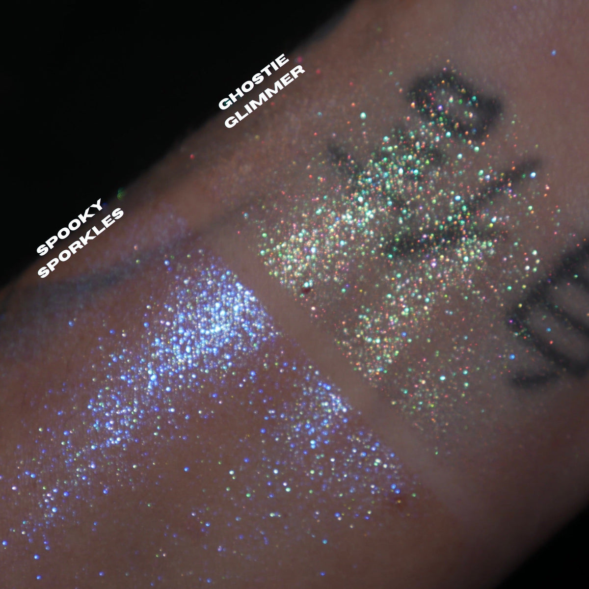 Spooky Sporkle and Ghostie Glimmer swatched side by side on a tattooed wrist, blue sparkle and multicoloured sparkle, brand labels