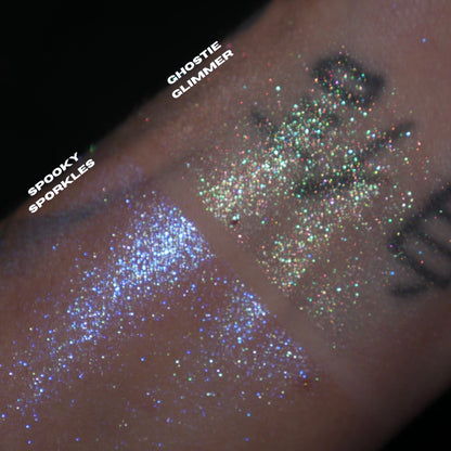 Spooky Sporkle and Ghostie Glimmer swatched side by side on a tattooed wrist, blue sparkle and multicoloured sparkle, brand labels