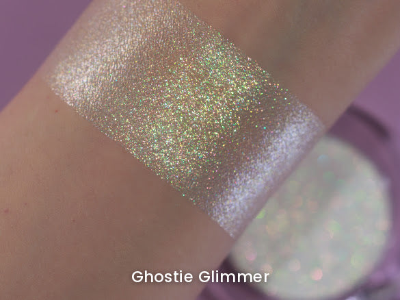 Ghostie Glimmer arm swatch on a lilac backdrop with the compact behind