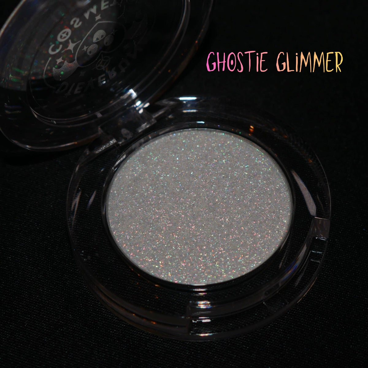 Ghostie Glimmer in its open clear round compact on a black background, brand label top right