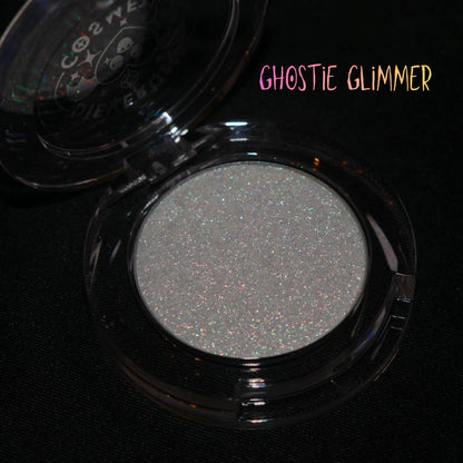 Ghostie Glimmer in its open clear round compact on a black background, brand label top right