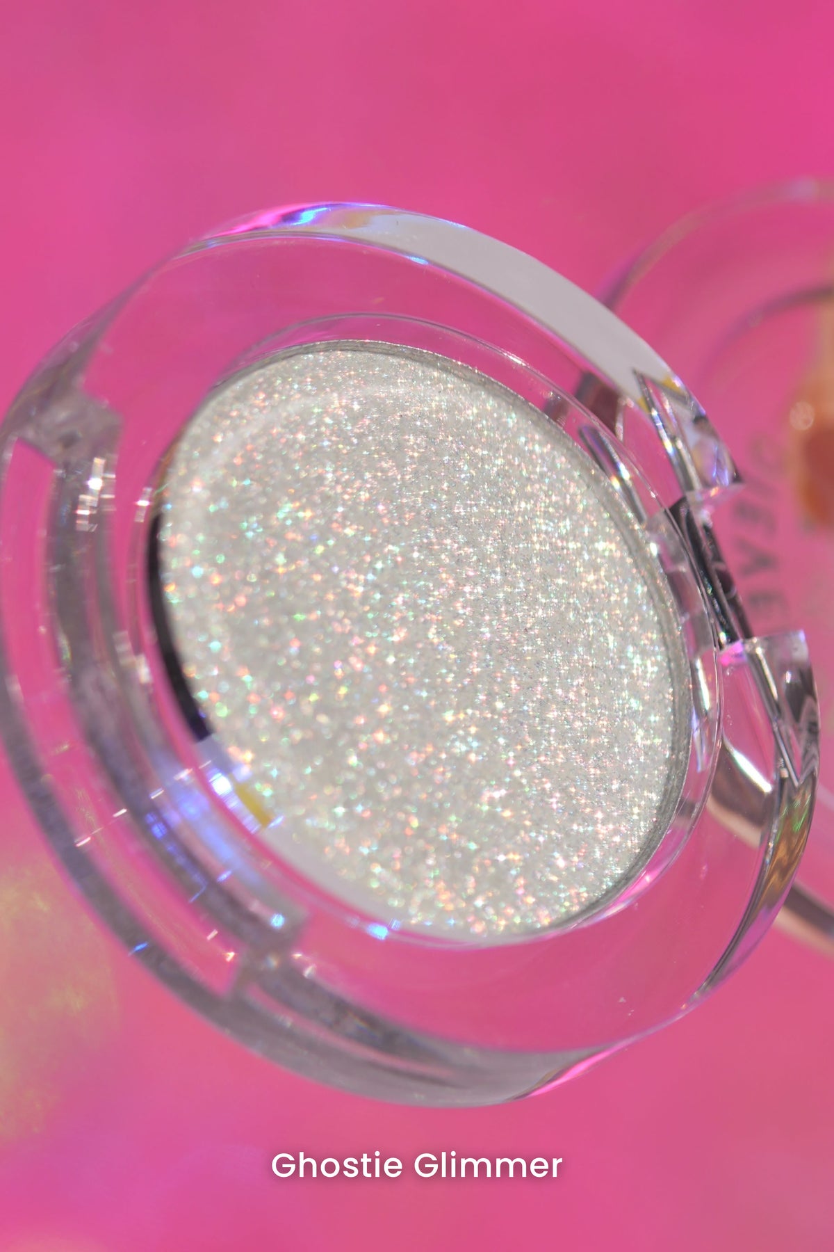 Ghostie Glimmer open clear compact angled against a pink backdrop