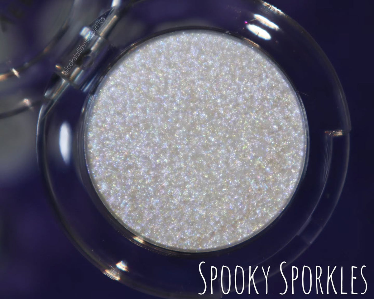 Spooky Sporkle open compact on a navy background, brand label lower right