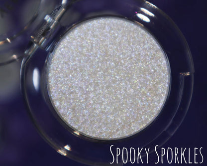 Spooky Sporkle open compact on a navy background, brand label lower right